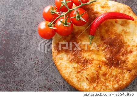 Georgian Mingrelian khachapuri topped with even more cheese close up. Horizontal top view Georgian Mingrelian khachapuri topped with even more cheese close up. Horizontal top view 85543950