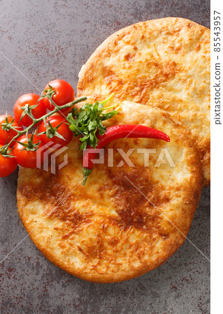 Georgian flat bread khachapuri with cheese close-up on the table. Vertical top view 85543957