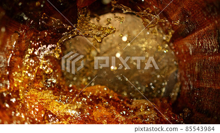 Freeze motion of splashing whisky in barrel 85543984