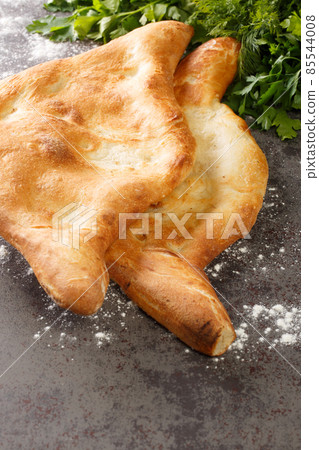 Shotis puri or shoti is a Georgian bread made with whole wheat flour, salt, water, and yeast close up. Vertical Shotis puri or shoti is a Georgian bread made with whole wheat flour, salt, water, and yeast close up. Vertical 85544008