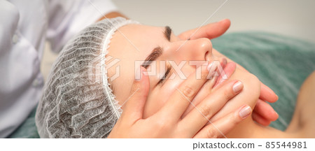 Face massage of detox therapy for the pretty female patient at spa salon. 85544981
