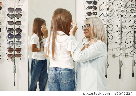 Family choosing glasses at optics store Family choosing glasses at optics store 85545224