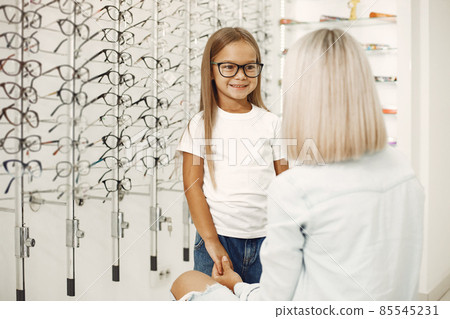 Family choosing glasses at optics store Family choosing glasses at optics store 85545231