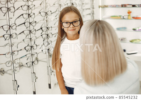Family choosing glasses at optics store Family choosing glasses at optics store 85545232