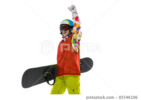 Happy young girl in bright sportswear, goggles and helmet standing with snowboard isolated on white studio background. Concept of winter sports Happy young girl in bright sportswear, goggles and helmet standing with snowboard isolated on white studio background. Concept of winter sports 85546106