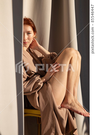 Young white european woman with curtains behind 85546447