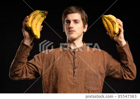 Young man with banana on black 85547363