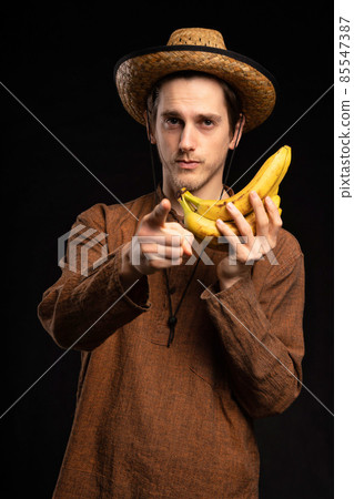 Young man with banana on black 85547387