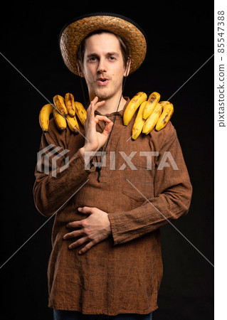Young man with banana on black Young man with banana on black 85547388