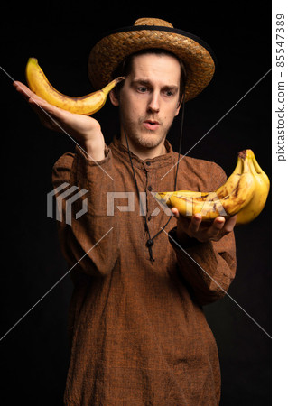 Young man with banana on black Young man with banana on black 85547389