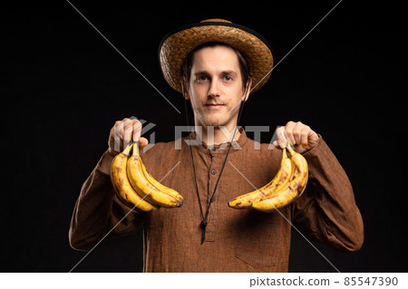 Young man with banana on black Young man with banana on black 85547390
