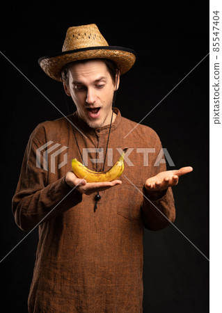 Young man with banana on black 85547404