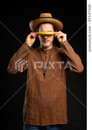 Young man with banana on black Young man with banana on black 85547406