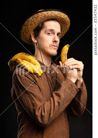 Young man with banana on black Young man with banana on black 85547432
