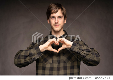 Young man in flannel shirt on grey Young man in flannel shirt on grey 85547574