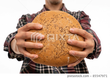 Young man with loaf of bread on white Young man with loaf of bread on white 85547971