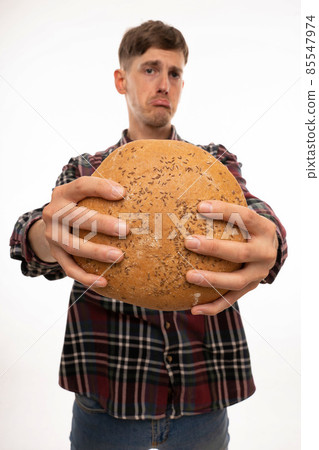 Young man with loaf of bread on white 85547974