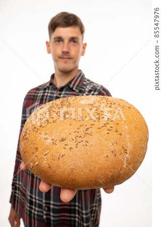 Young man with loaf of bread on white 85547976