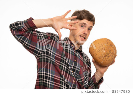 Young man with loaf of bread on white 85547980
