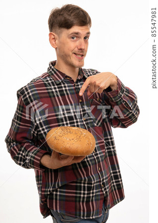 Young man with loaf of bread on white Young man with loaf of bread on white 85547981
