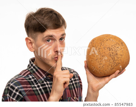 Young man with loaf of bread on white Young man with loaf of bread on white 85547983