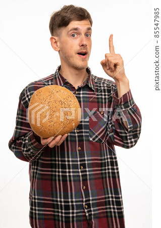 Young man with loaf of bread on white Young man with loaf of bread on white 85547985