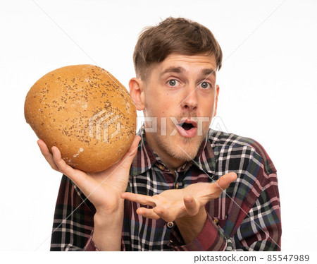 Young man with loaf of bread on white Young man with loaf of bread on white 85547989