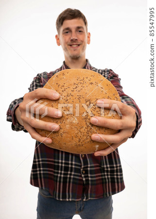 Young man with loaf of bread on white Young man with loaf of bread on white 85547995