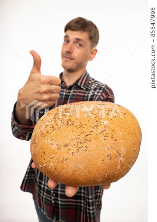 Young man with loaf of bread on white Young man with loaf of bread on white 85547998
