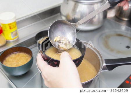 A woman's hand to put clam miso soup A woman's hand to put clam miso soup 85548499