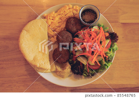 Pita bread, falafel, hummus, salad and scrambled eggs for a healthy modern middle eastern breakfast Pita bread, falafel, hummus, salad and scrambled eggs for a healthy modern middle eastern breakfast 85548765