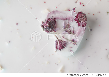 Frozen milk ice block in heart shape with flowers floating in milk, dry ice smoke. Love romantic concept 85549244