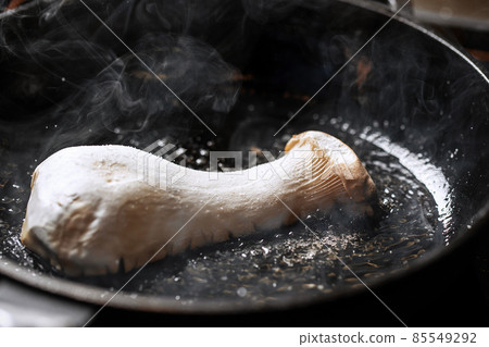 Pleurotus eryngii king oyster mushroom frying in iron cast pan creating beautiful steam Pleurotus eryngii king oyster mushroom frying in iron cast pan creating beautiful steam 85549292