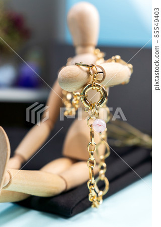 Gold chain natural mixed pink rose quartz necklace. Selective focus Gold chain natural mixed pink rose quartz necklace. Selective focus 85549403