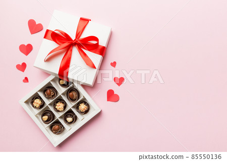 Delicious chocolate pralines in red box for Valentine's Day. Heart shaped box of chocolates top view with copy space Delicious chocolate pralines in red box for Valentine's Day. Heart shaped box of chocolates top view with copy space 85550136