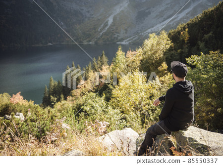 Man tourist relaxing on the top of a hill 85550337