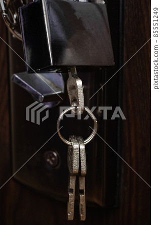 Key and lock on a wooden door close up 85551249