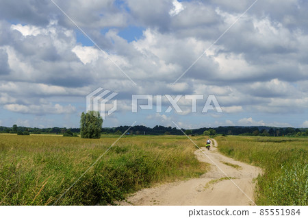 A long road in an arable field. Farmland. A beautiful field road A long road in an arable field. Farmland. A beautiful field road 85551984