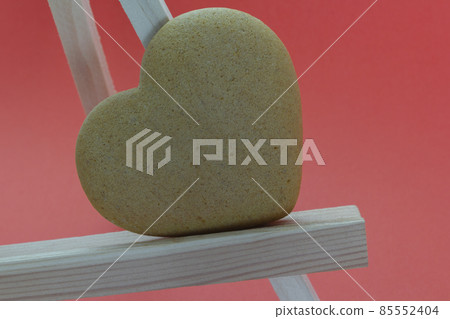 heart shaped homemade gingerbread on a light wooden stand red background, Valentine's Day, greeting card, pastry, Copy space, top view, love concept, Engagement, love 85552404