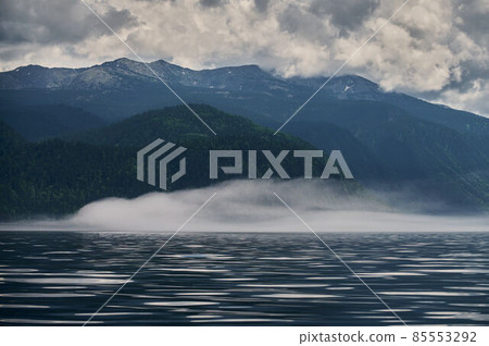 Fog in the mountain valley. Morning fog over the lake in the Altai mountains. Fog in the mountain valley. Morning fog over the lake in the Altai mountains. 85553292