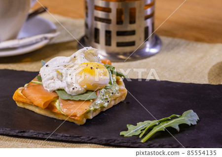 Poached egg on toast, with smoked salmon, avocado, grilled tomato, and baby spinach. Poached egg on toast, with smoked salmon, avocado, grilled tomato, and baby spinach. 85554135