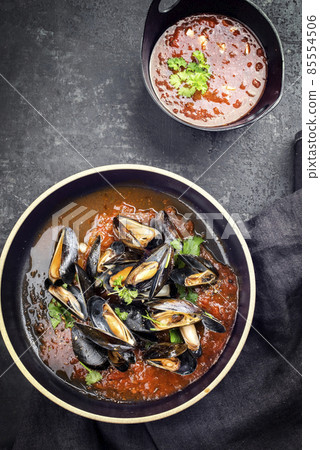 Italian blue mussel in tomato sauce with parsley and garlic in red wine sauce Italian blue mussel in tomato sauce with parsley and garlic in red wine sauce 85554506