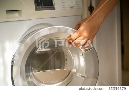 Man is using the modern washing mashine. Man is using the modern washing mashine. 85554879