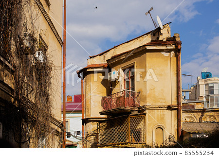 Odessa, Ukraine - 04 24 21: A part of old building facade with windows and balcony. Typical houses in old town city center. Sunny spring photo 85555234