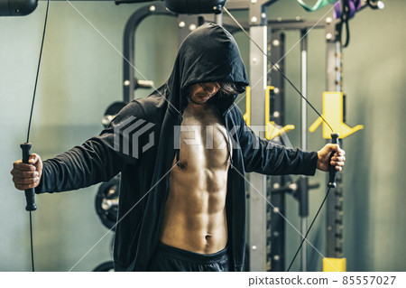 A man using a cable machine in a gym A man using a cable machine in a gym 85557027