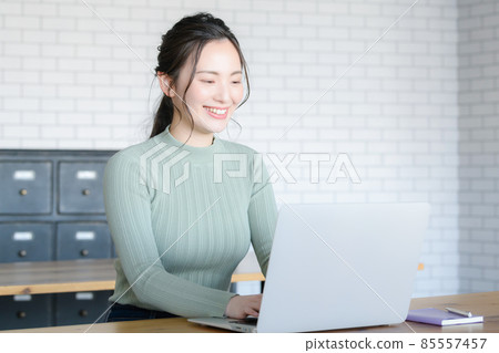 Japanese women typing with a smile while looking at a computer There is a copy space Japanese women typing with a smile while looking at a computer There is a copy space 85557457