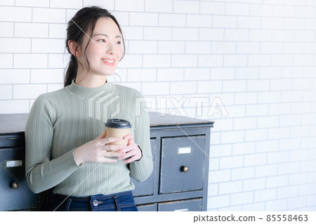 一邊喝咖啡一邊微笑的女性，有復印空間。 85558463