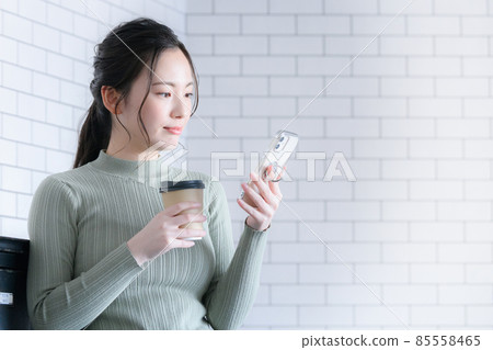 A female who searches for a smartphone with coffee has a copy space 85558465