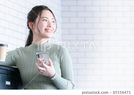A smiling woman taking a break with coffee has a copy space A smiling woman taking a break with coffee has a copy space 85558471
