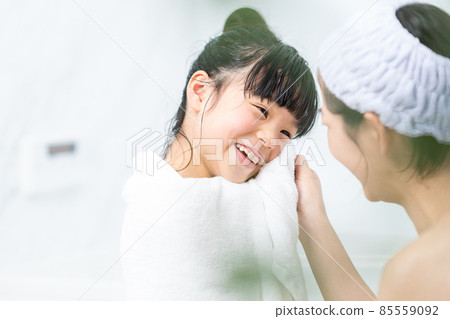 Mother wiping her daughter after taking a bath 85559092